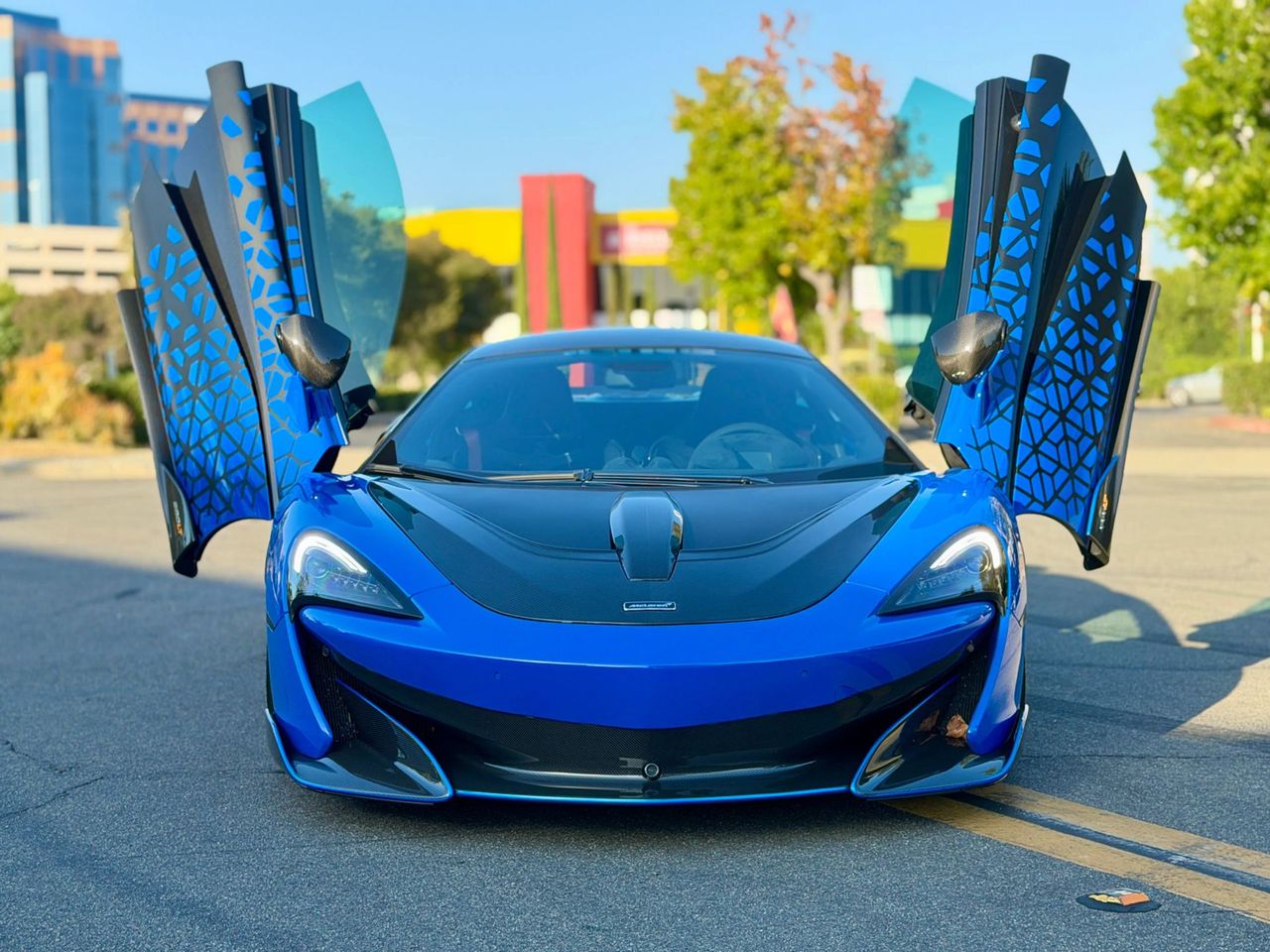 Blue 2019 McLaren 600LT with doors up, in stock at Scuderia Motorcars